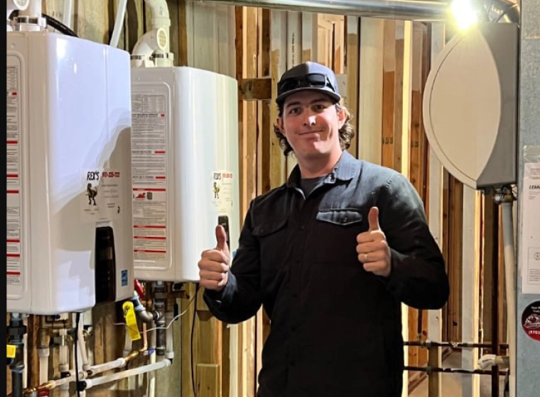 a plumber giving thumbs up with tanklesss water heaters by his side